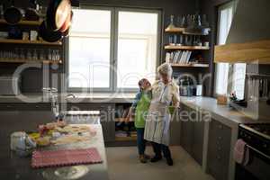 Grandmother and granddaughter embracing in the kitchen