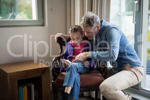 Father and daughter reading a book at home