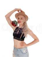 Beautiful woman with hat and rose in mouth