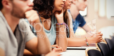 Side view of students listening lecturer