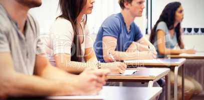 Studious young adults listening in classroom