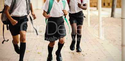 Smiling school kids running in corridor