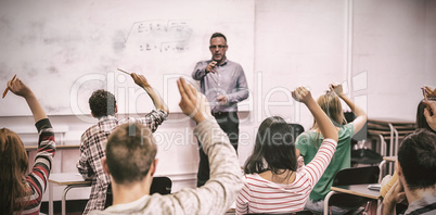 Students raising hands in classroom