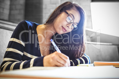 Focused student writing on notebook