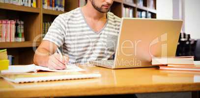 Student studying in library with laptop