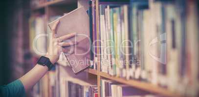 Students hand with smartwatch picking book from bookshelf