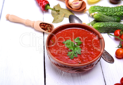Cold gazpacho soup in a brown ceramic plate