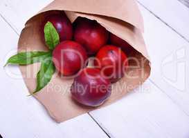 Ripe red peaches in a paper bag