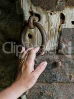 Woman's hand holds the ring of the ancient gate