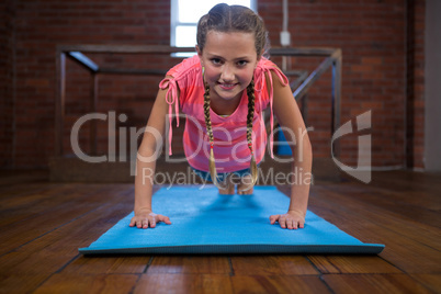 Portrait of happy teenage girl doing pushup