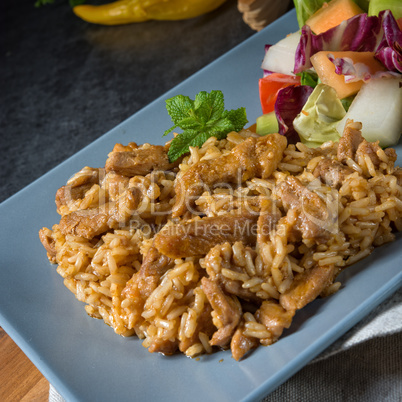 Meat strips in spicy sweet and sour sauce and green salad