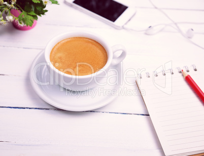 cup of coffee and an empty paper notebook