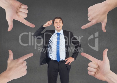 Hands pointing at business man against grey background