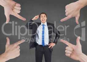 Hands pointing at business man against grey background