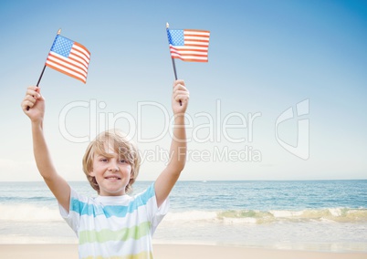 Happy boy holding USA flags in the beach