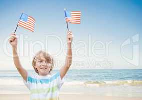 Happy boy holding USA flags in the beach