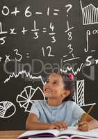 Happy student girl at table looking up against grey blackboard with education and school graphics