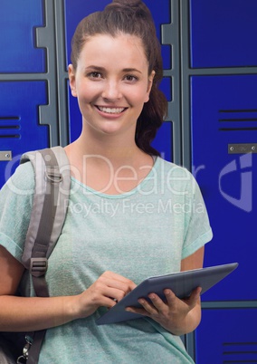 female student holding tablet in front of lockers