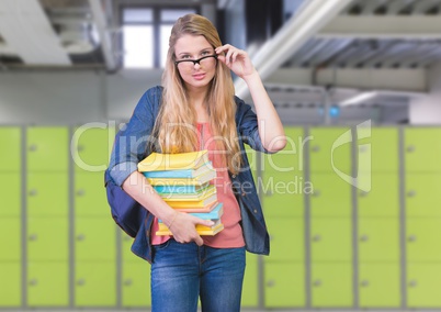 female student holding books in front of lockers