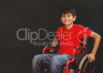 Disabled boy in wheelchair in front of blackboard