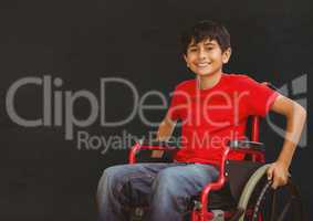 Disabled boy in wheelchair in front of blackboard