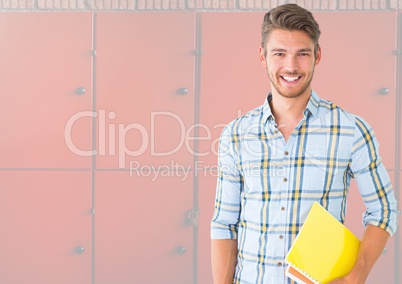 male student holding book in front of lockers