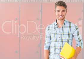 male student holding book in front of lockers