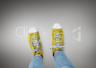 Yellow shoes on feet with grey background