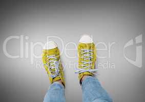 Yellow shoes on feet with grey background