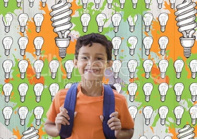 Schoolboy in front of light bulb graphics and orange and green paint