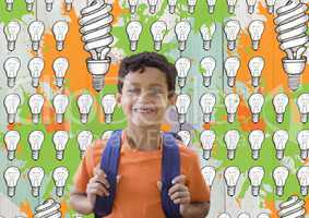 Schoolboy in front of light bulb graphics and orange and green paint