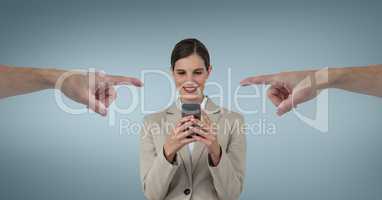 Hands pointing at happy business woman using her phone against blue background