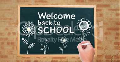 Hand drawing Welcome back to school text and flowers  on blackboard
