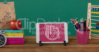 Tablet on a school table with school icons on screen