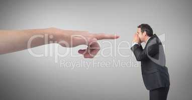 Hand pointing at angry business man against grey background