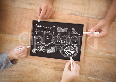 Hands writing equations on blackboard