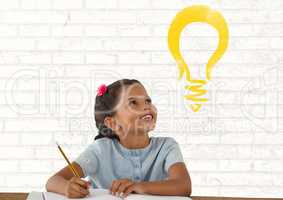 Schoolgirl writing  at desk with light bulb