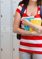 female student holding books in front of lockers