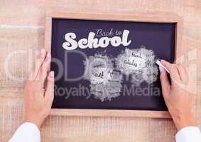 Hand writing school subjects and back to school text on blackboard