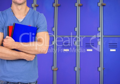 male student holding books in front of lockers