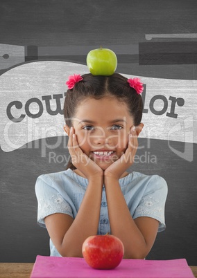Happy student girl at table against grey blackboard with education and school graphics