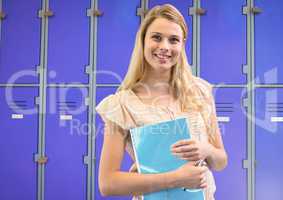 female student holding book in front of lockers