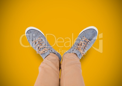 Grey shoes on feet with yellow background