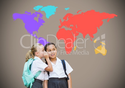 School girls whispering in front of colorful world map