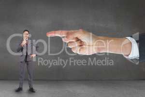 Hand pointing at business man against grey background