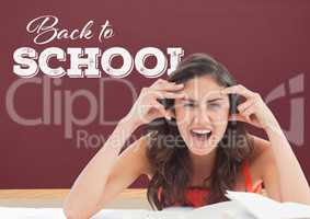Frustrated student girl at table against red blackboard with back to school text