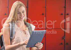 female student holding tablet in front of lockers