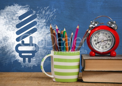 Desk foreground with blackboard graphics of light bulb energy