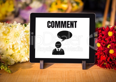 Comment text and chat graphic on tablet screen with flowers