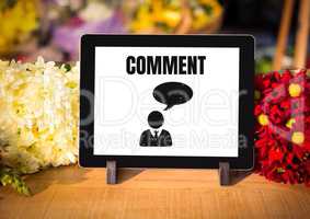 Comment text and chat graphic on tablet screen with flowers